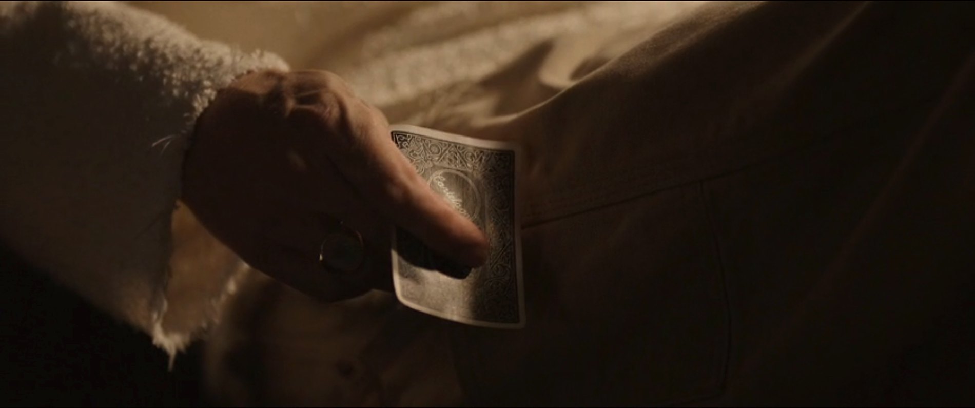 A close-up of a hand holding a playing card