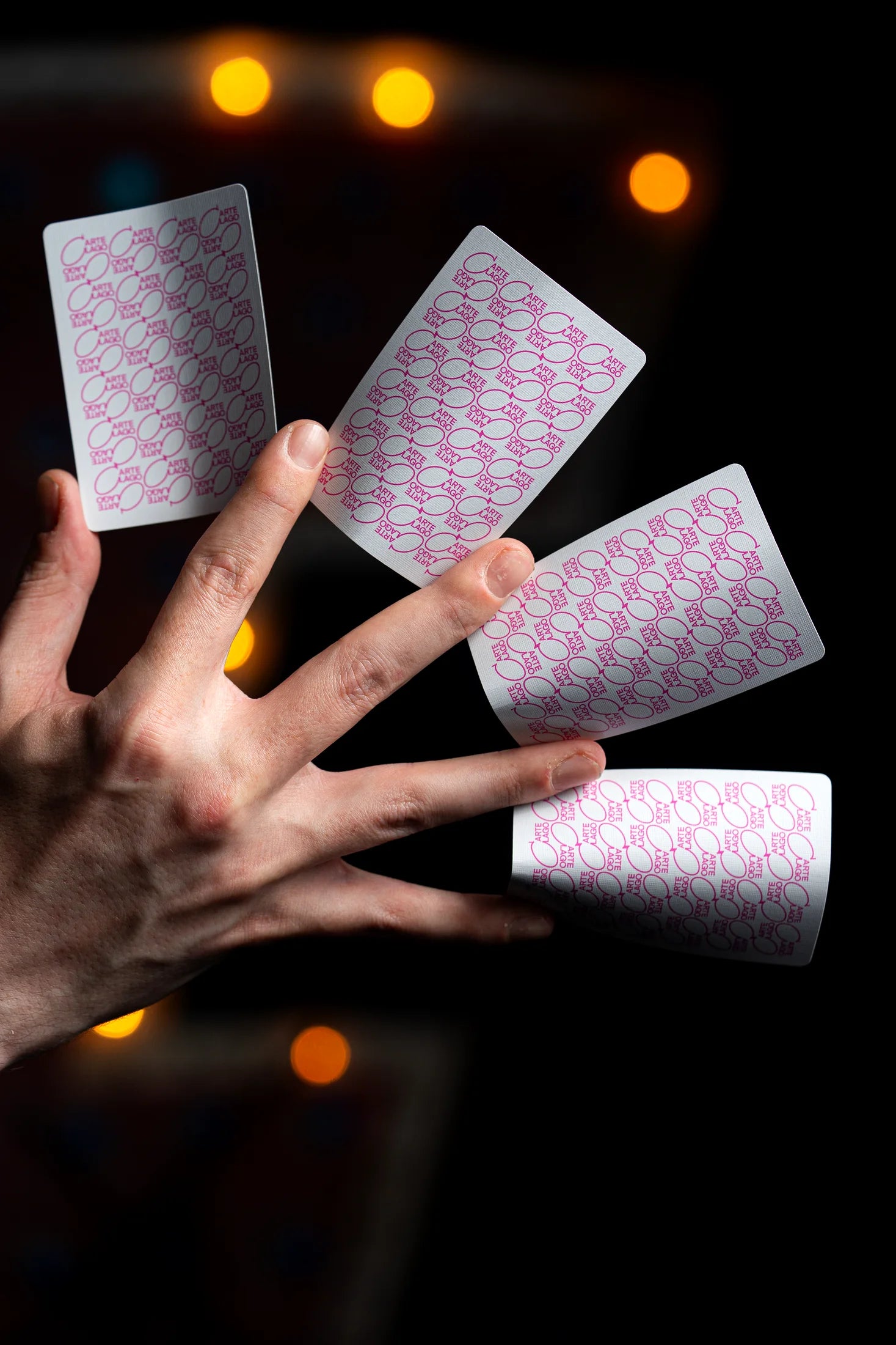 Players cards balanced across a cardist's fingers